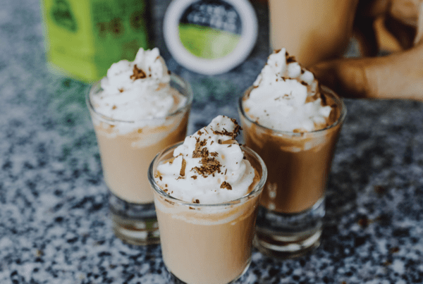 four shot glasses with Irish Coffee and whipped cream