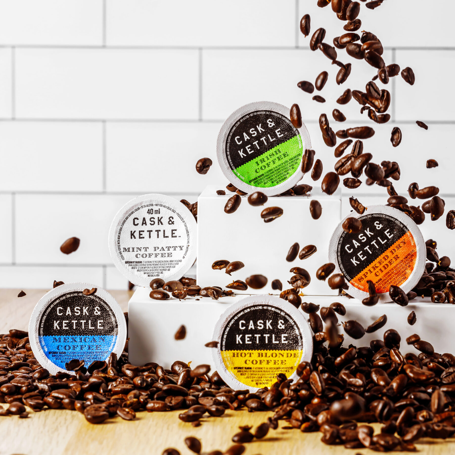 five coffee cocktail pods on a kitchen counters set on a bed of coffee beans